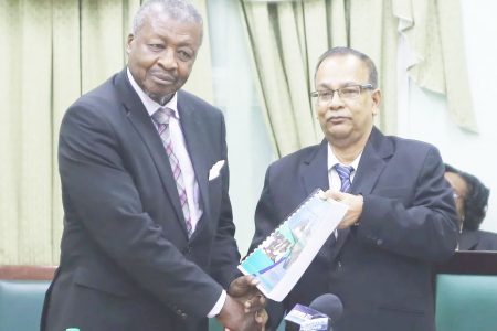 Speaker of the National Assembly Dr. Barton Scotland (left) accepting the 2017 Auditor General’s Report from Auditor General Deodat Sharma at the Public Buildings. The 2018 report, which was handed over last year, was not laid in the Assembly before its dissolution. 