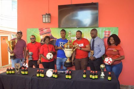 Gregory ‘Jackie Chan’ Richardson (in blue) and Corporate Communications Officer Treiston Joseph (third from right), display the championship trophy.
