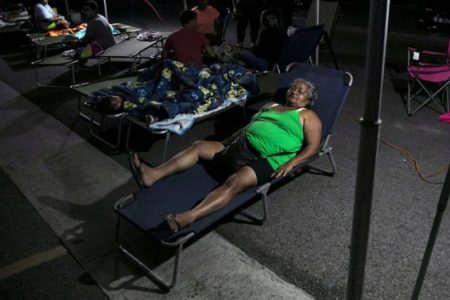 People rest at a makeshift camp outside their apartment building after an earthquake in Yauco, Puerto Rico. Photograph: Marco Bello/Reuters