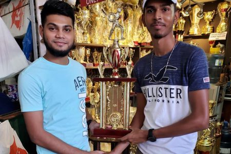 Trophy stall representative, Lakeram Narine (left) presents Troy Persaud from Mc Gill Super Stars Sports Club with one of the prizes to distribute tomorrow.