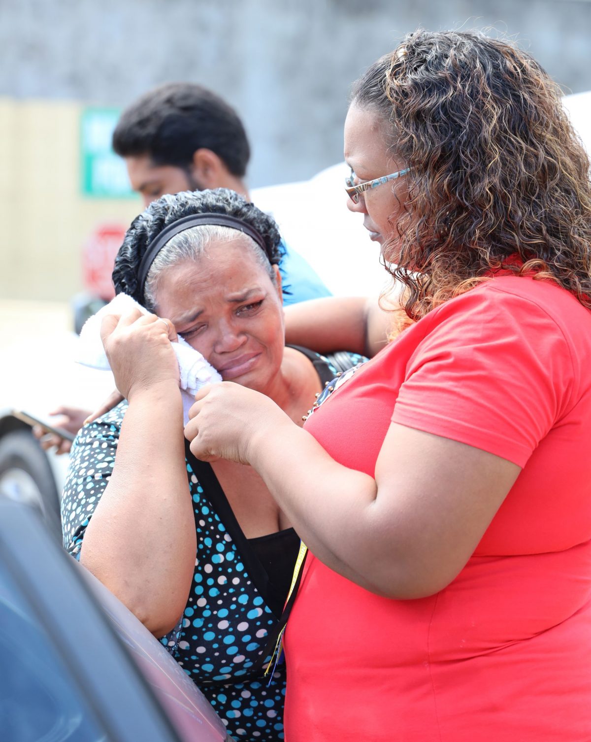Paula Chuniesingh, left, is consoled by a relative after viewing the bodies of her children Pollyann and Damian Chuniesingh, at the Forensic Science Centre, St James, yesterday.