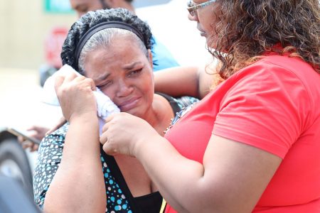 Paula Chuniesingh, left, is consoled by a relative after viewing the bodies of her children Pollyann and Damian Chuniesingh, at the Forensic Science Centre, St James, yesterday.