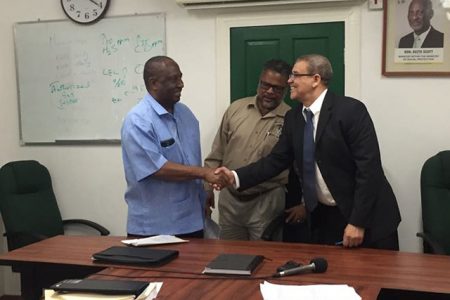 GPSU President Patrick Yarde (at left) and Commissioner-General of the GRA Godfrey Statia shake hands after signing the agreement as Chief Labour Officer Charles Ogle watches on.
