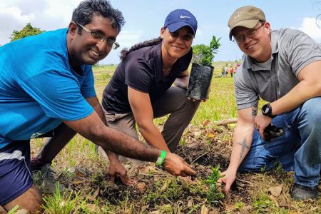 Economist Dr Roger Hosein (left) plants a tree along with members of the US Public Affairs Unit of the US Embassy
