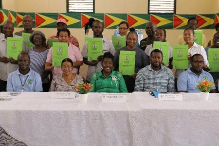 Some of the new leaseholders (standing with their leases) along with Minister within the Ministry of Agriculture Valarie Patterson-Yearwood (seated third, from left), with GL&SC managers and regional officials after last Friday’s handing over. (GL&SC photo)
