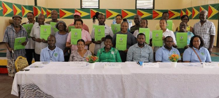 Some of the new leaseholders (standing with their leases) along with Minister within the Ministry of Agriculture Valarie Patterson-Yearwood (seated third, from left), with GL&SC managers and regional officials after last Friday’s handing over. (GL&SC photo)
