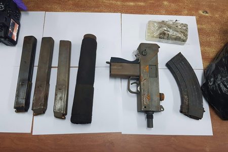 The sub-machine gun, silencer and magazines that were discovered by the police during an intelligence-led operation last year. (Guyana Police Force photo)
