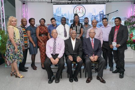 President David Granger (seated at centre), with Banks DIH Chairman Clifford Reis (seated at right) and Banks DIH Human Resources Director Paul Carto (seated left) with awardees (Ministry of the Presidency photo)