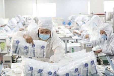 Employees work on a medical supply production line at a factory in Huaian, Jiangsu province, China February 28, 2020. China Daily via REUTERS