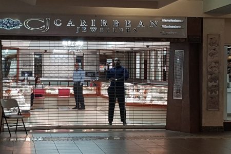 The owners of Caribbean Jewellers survey the losses incurred following the midday robbery at the Gulf City Mall, Lowlands, Tobago, on Monday.