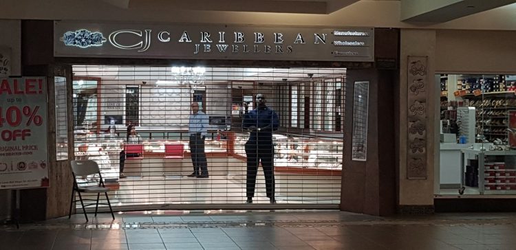 The owners of Caribbean Jewellers survey the losses incurred following the midday robbery at the Gulf City Mall, Lowlands, Tobago, on Monday.