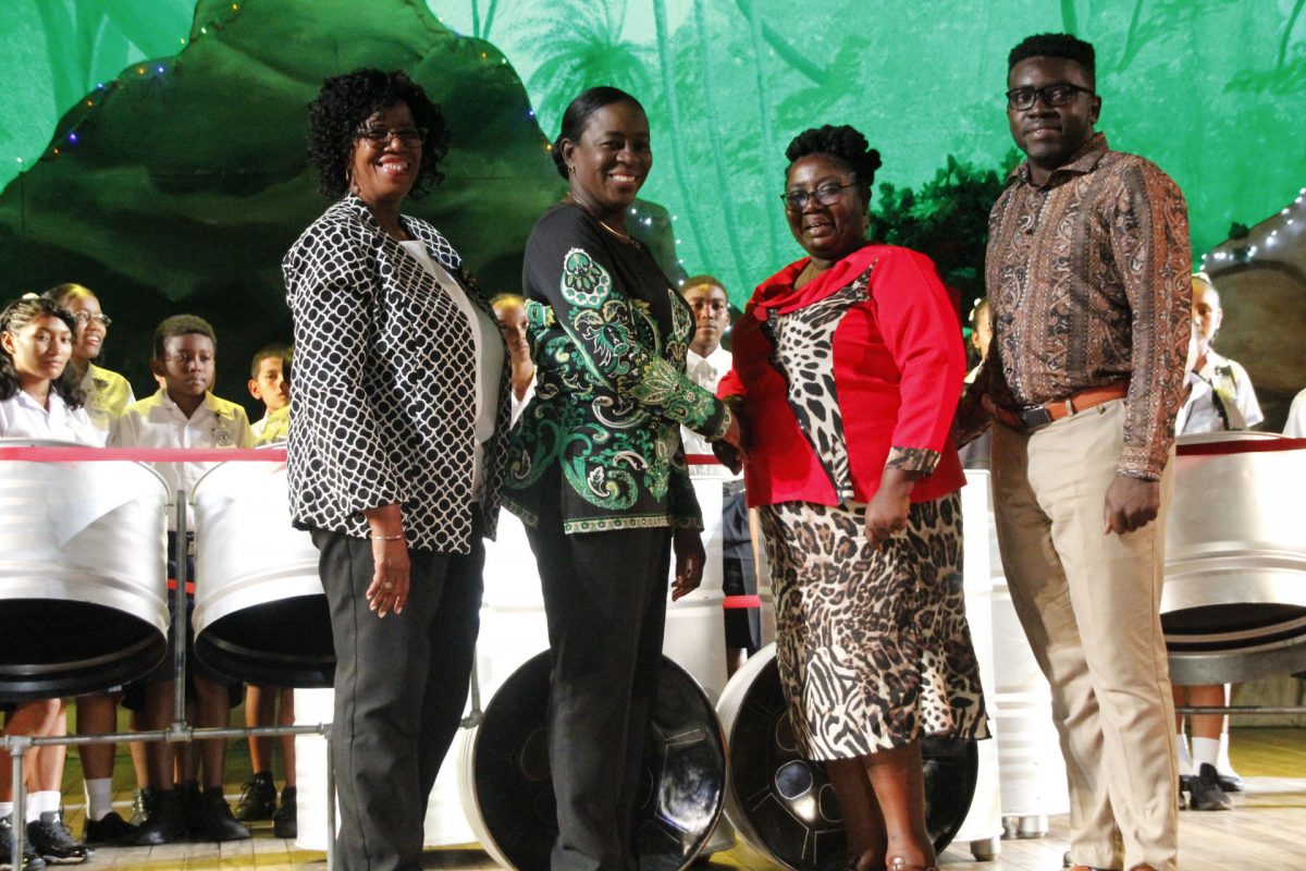 Minister Nicolette Henry (second from left) hands over the steel pans to Regional Education Officer of Region Eight,  Penelope McIntosh and a teacher of the Mahdia Secondary School. (Ministry of Education photo)
