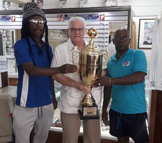 Team Guyana captain Omally Nassy [left] posing alongside his SV Ratio counterpart  Fineal Burgzone [right] with the prestigious Modern Optical Trophy prior to the second meeting. The accolade will be awarded to the winning team of the Goodwill International Masters Football Championship
