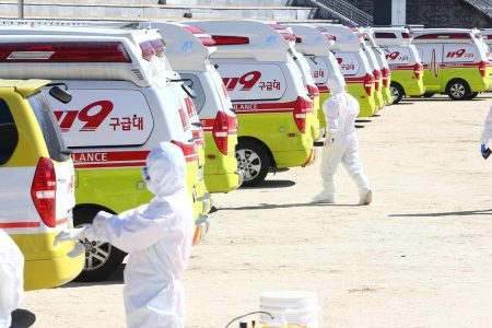 Medical workers get ready as ambulances are parked to transport a confirmed coronavirus patient in Daegu, South Korea, February 23, 2020. Yonhap via REUTERS
