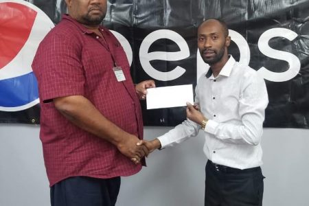 DDL Marketing Executive Larry Wills (right) hands over sponsorship to RHTYSC Secretary/CEO Hilbert Foster.
