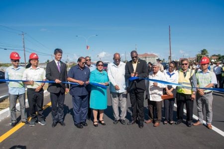 Sita Nagamootoo (centre) cuts the ribbon to commission the US$43M ECD Road Enhancement Project. (DPI photo)