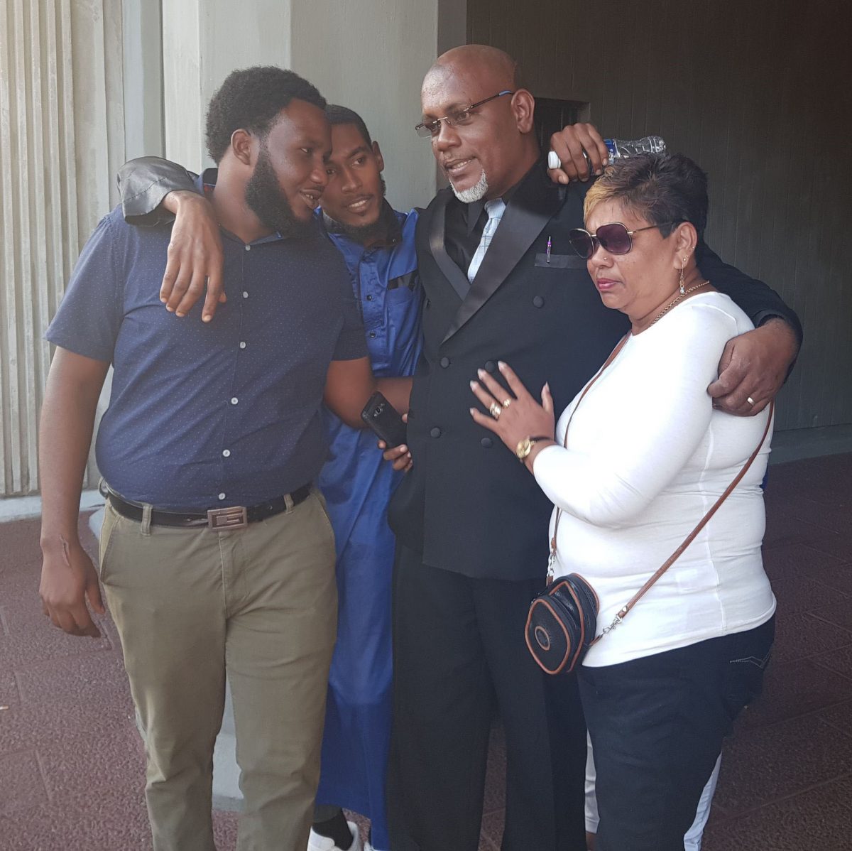 Sheldon Reid is embraced by loved ones after he was freed at the Hall of Justice, Port-of-Spain, yesterday.