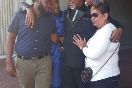 Sheldon Reid is embraced by loved ones after he was freed at the Hall of Justice, Port-of-Spain, yesterday.