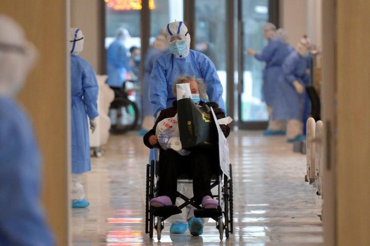 A medical worker in protective suit moves a novel coronavirus patient in a wheelchair at a hospital in Wuhan, Hubei province, China February 10, 2020. Picture taken February 10, 2020. China Daily via REUTERS
