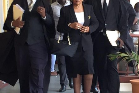 Chairperson of the Guyana Elections Commission (GECOM) Justice (ret’d) Claudette Singh (centre) and Senior Counsel Neil Boston (at left) making their way out of the court room to attend a meeting yesterday morning.

