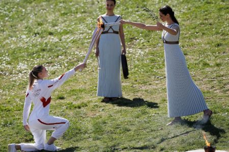 Greek actress Xanthi Georgiou, playing the role of High Priestess passes the flame to the first torchbearer, Greek shooting athlete Anna Korakaki, during the opening of the Olympic flame torch relay for the Tokyo 2020 Summer Olympics yesterday. (REUTERS/Costas Baltas)
