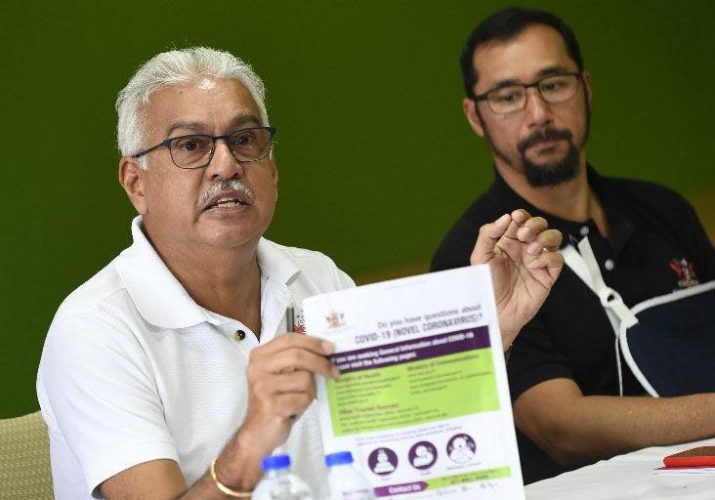 Health Minister Terrence Deyalsingh, left, displays a COVID-19 guidelines poster during yesterday’s news conference at the Ministry of Health on Park Street, Port of Spain. At right is National Security Minister Stuart Young. (Trinidad Express photo)