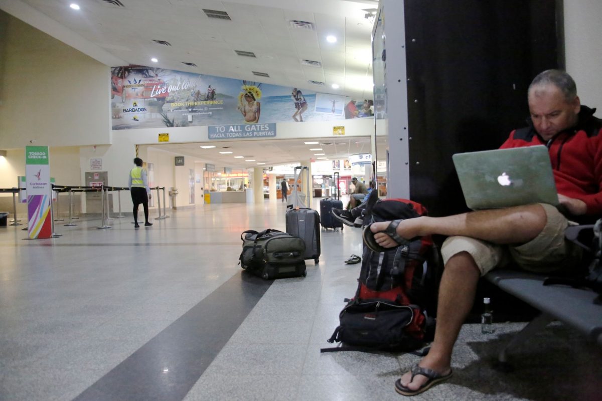 A passanger waits at the check out area at Piarco International Airport on Tuesday night.