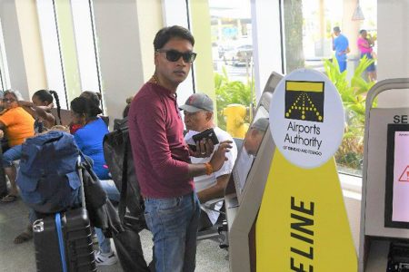 Princes Town MP Barry Padarath uses a self-serve check-in kiosk at Piarco International Airport. The airport was closed for all flights to combat the spread of the COVID-19 virus.