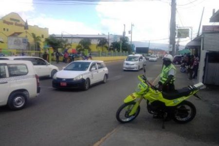 A cop in Santa Cruz, St Elizabeth, keeping an eye on traffic last week. The traffic situation has been blamed for providing an easy escape for bike-riding robbers in the town.