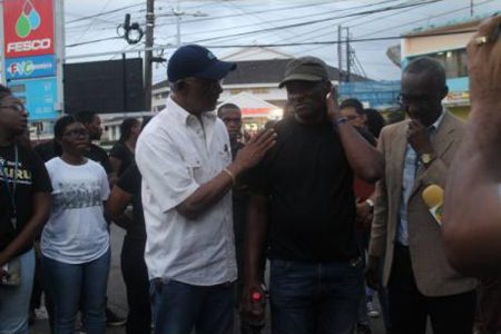 Co-owner and operator of Heaven’s FESCO service station, Trevor Heaven (left), consoling Errol Wisdom, whose wife and daughter were badly injured in the explosion at the gas station in Mandeville, Manchester, last month. At right is Sefton Brown from the Northern Caribbean University.