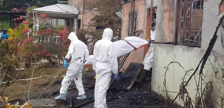 One of the victims being removed from the burnt out home. Photo: Trevor Watson