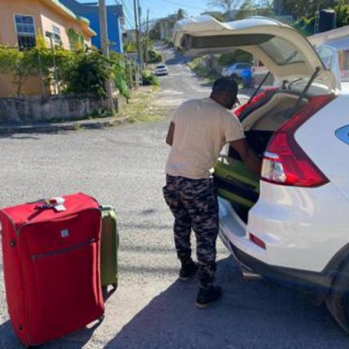 
Contributed
Dennis Grey offloading his suitcases after arriving home following his hurried flight from the United States.