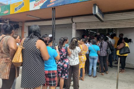 Persons waiting their turn to enter the Beepats Supermarket on Regent Street. 