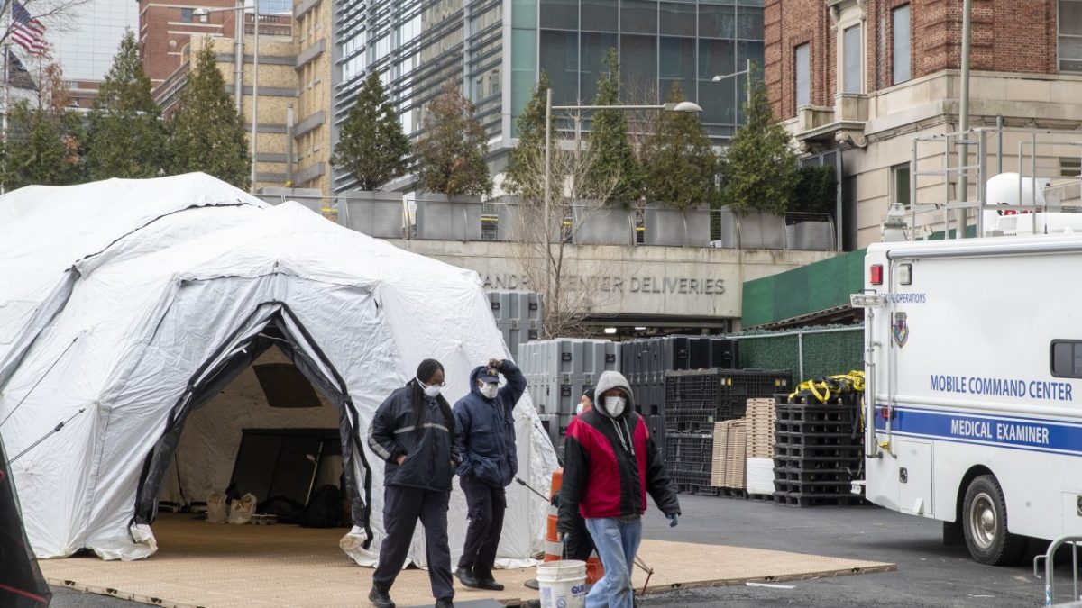Medical and construction workers are seen at the site of a makeshift morgue that was built outside a hospital in New York on Wednesday.