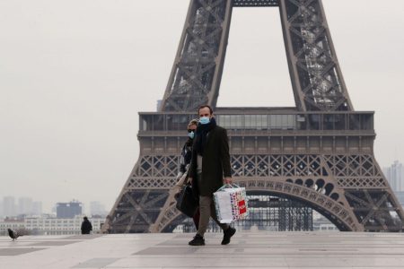 A masked couple walks on the empty Trocadero next to the Eiffel Tower, in Paris, France.