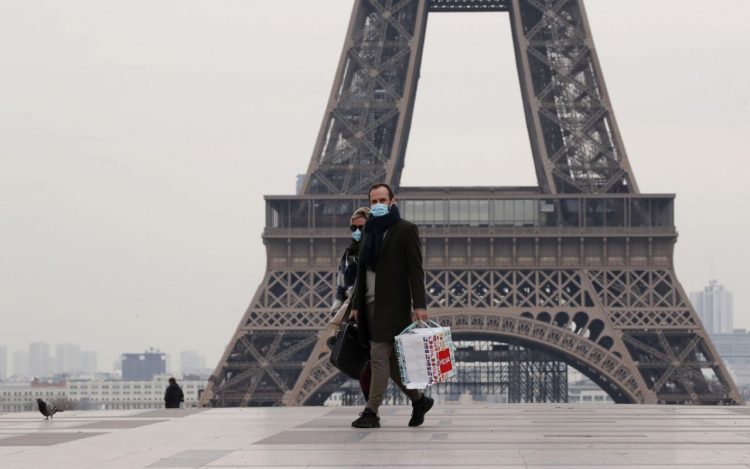 A masked couple walks on the empty Trocadero next to the Eiffel Tower, in Paris, France.