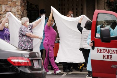 Medics and other healthcare workers transfer a patient on a stretcher to an ambulance at the Life Care Center of Kirkland, the long-term care facility linked to the two of three confirmed coronavirus cases in the state, in Kirkland, Washington, U.S. March 1, 2020. REUTERS/David Ryder