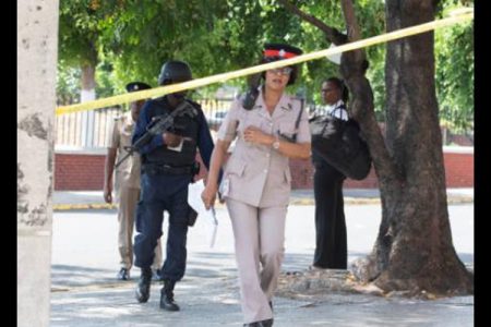 Members of the Jamaica Constabulary Force at the cordoned crime scene where an alleged thief was shot dead on Monday, March 23, at East Parade in the vicinity of Coke Memorial Methodist Church.