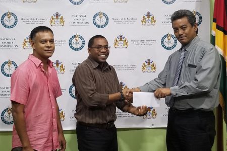 Seon Erskine makes a donation on behalf of the NSC to the  Guyana Chess Federation.