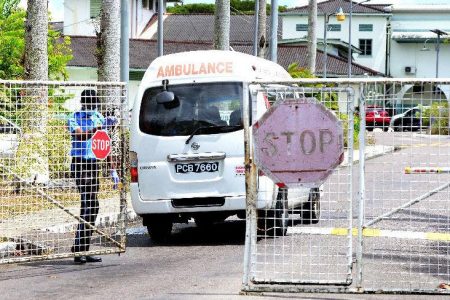 COVID-19 quarantine facility: A security officer opens the gate for an ambulance to enter the Caura Hospital, at Caura Royal Road, El Dorado, on Friday. —Photo: ISHMAEL SALANDY