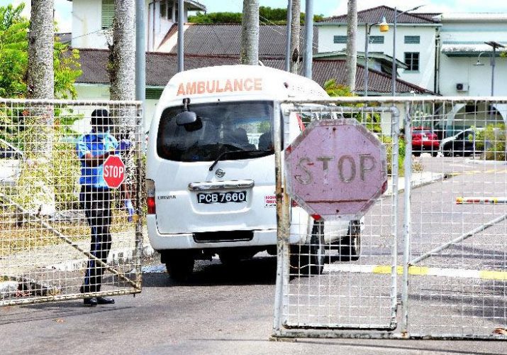 COVID-19 quarantine facility: A security officer opens the gate for an ambulance to enter the Caura Hospital, at Caura Royal Road, El Dorado, on Friday. —Photo: ISHMAEL SALANDY