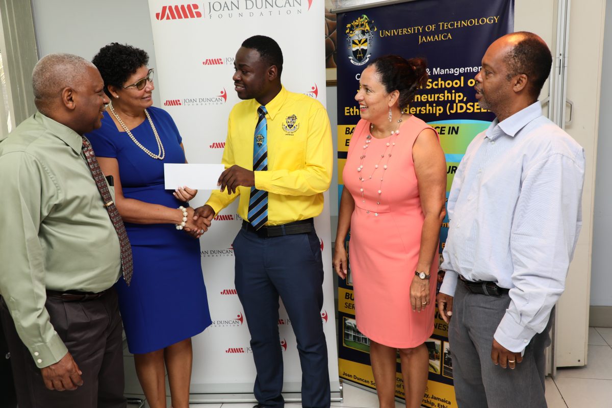 Patricia Duncan-Sutherland (second left), chairman, JMMB Joan Duncan Foundation, presents a cheque from the JMMB Trust Fund to Rayvon Stewart on June 9, 2019 while (from left) Professor Paul Golding, dean, College of Business and Management, UTech, Jamaica; Donna Duncan-Scott, group executive director, culture and human development, JMMB Group; and Nigel Cooper, head of the Joan Duncan School of Entrepreneurship, Ethics and Leadership, UTech, look on.
