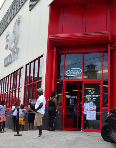 The Bounty Supermarket on Regent Street was seen opened with customers outside waiting in line to enter the establishment as the company put measures in place to promote social and physical distancing (Orlando Charles photo) 