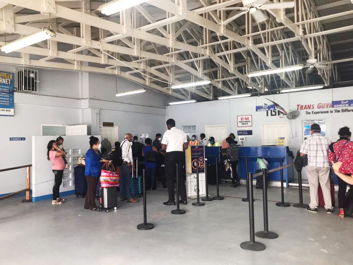 Some of the Canadians waiting in line to board a flight to Barbados at the Eugene F. Correia International Airport yesterday 
