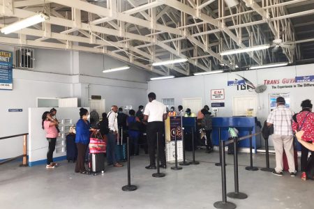 Some of the Canadians waiting in line to board a flight to Barbados at the Eugene F. Correia International Airport yesterday 