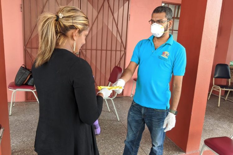 A United National Congress activists give a free mask to a member of the public in Central earlier this week.