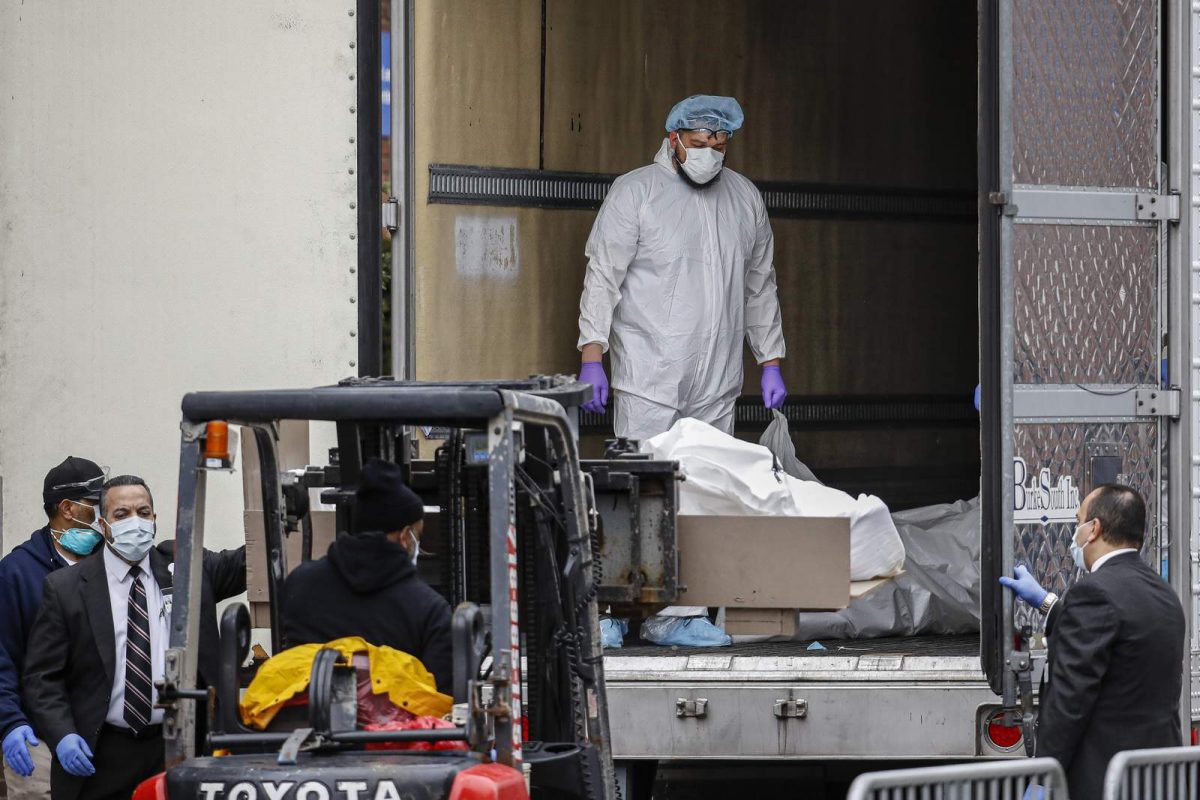 A body wrapped in plastic is loaded onto a refrigerated container truck used as a temporary morgue by medical workers wearing personal protective equipment due to COVID-19 concerns last week at Brooklyn Hospital Center in the Brooklyn borough of New York.