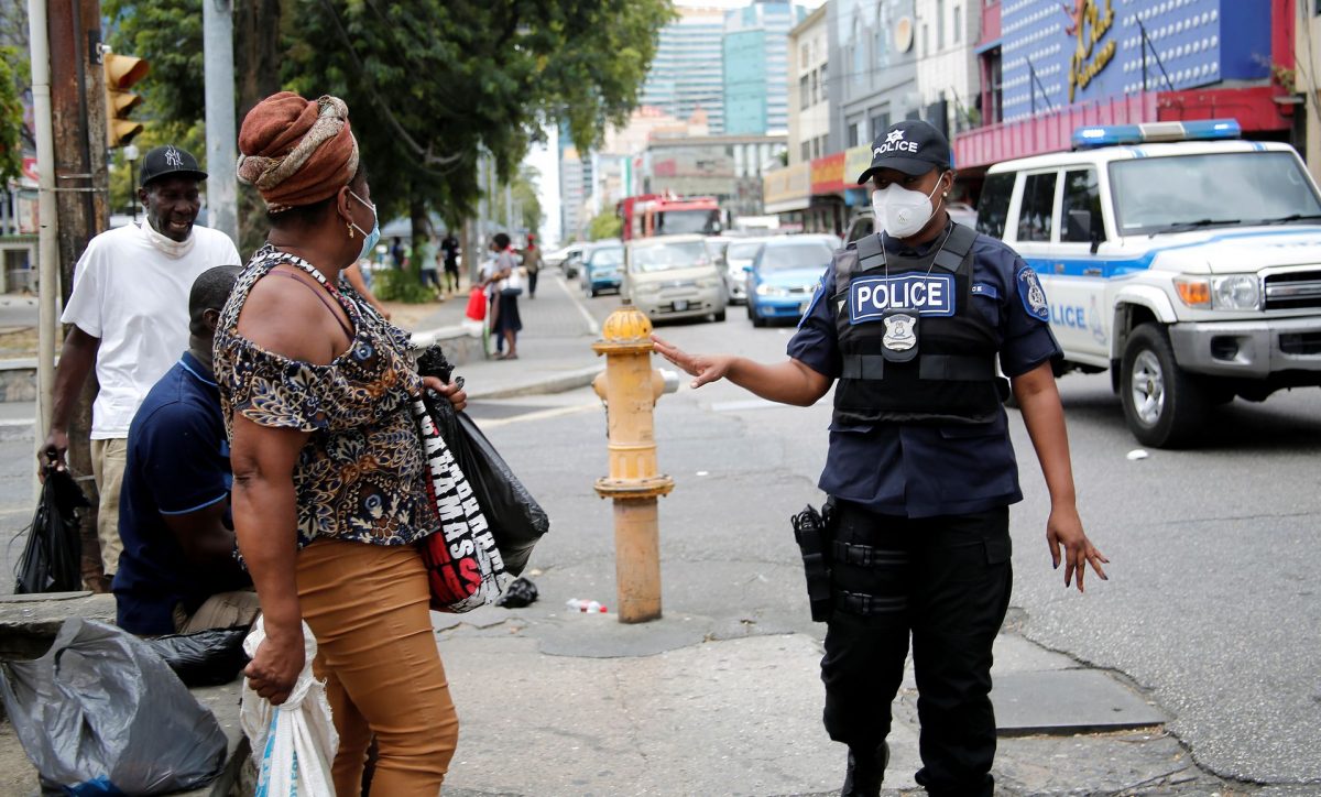 A police officer attached to IATF unit pleads with members of the public to stop gathering on the Brian Lara Promenade, Port-of- Spain, yesterday.