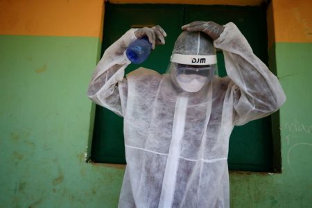 A health worker sprays his headset during a community testing exercise, as authorities race to contain the spread of the coronavirus disease (COVID-19) in Abuja
