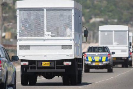 Deportees peer from a caged truck as a motorcade transporting the Jamaicans travels along the Palisadoes strip in Kingston on Tuesday, April 21. The 46 deportees have been placed under a 14-day quarantine to guard against the further spread of COVID-19.